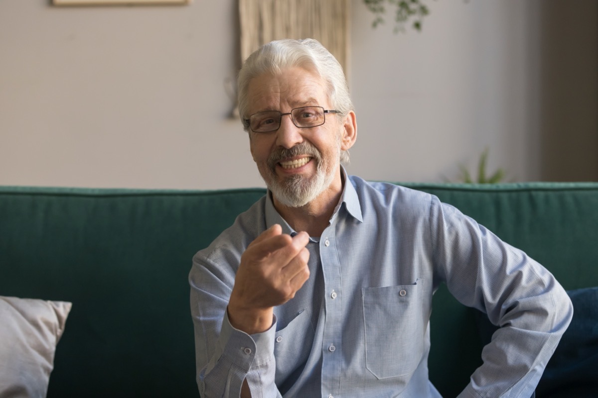 smiling grey haired man looking at camera, making video call