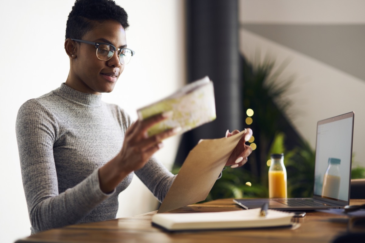 young black woman in glasses opening mail