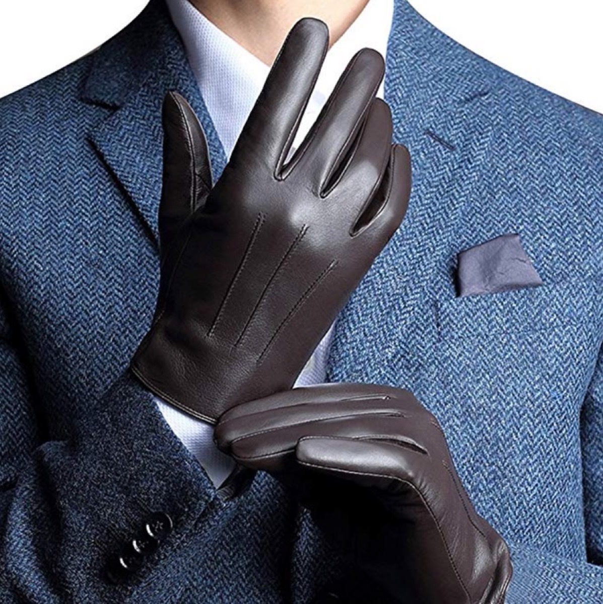 man putting on brown leather gloves