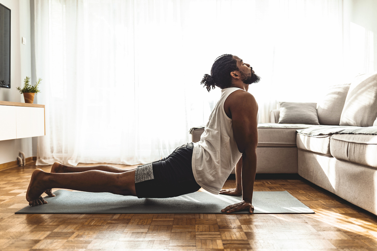 A man doing yoga in his living room.