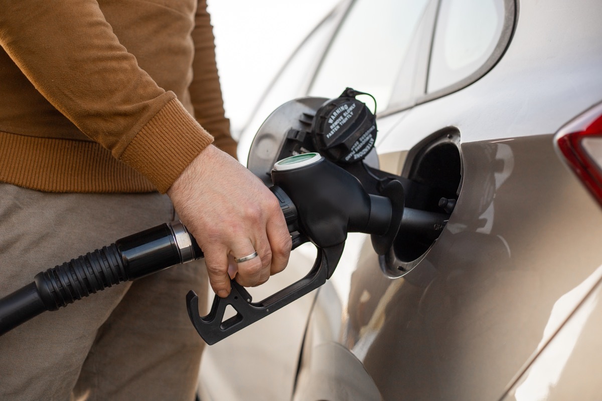 Close-up on driver filling car with gas