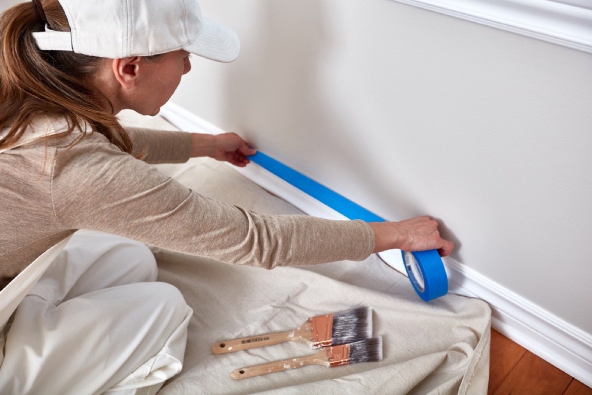 woman taping baseboard molding