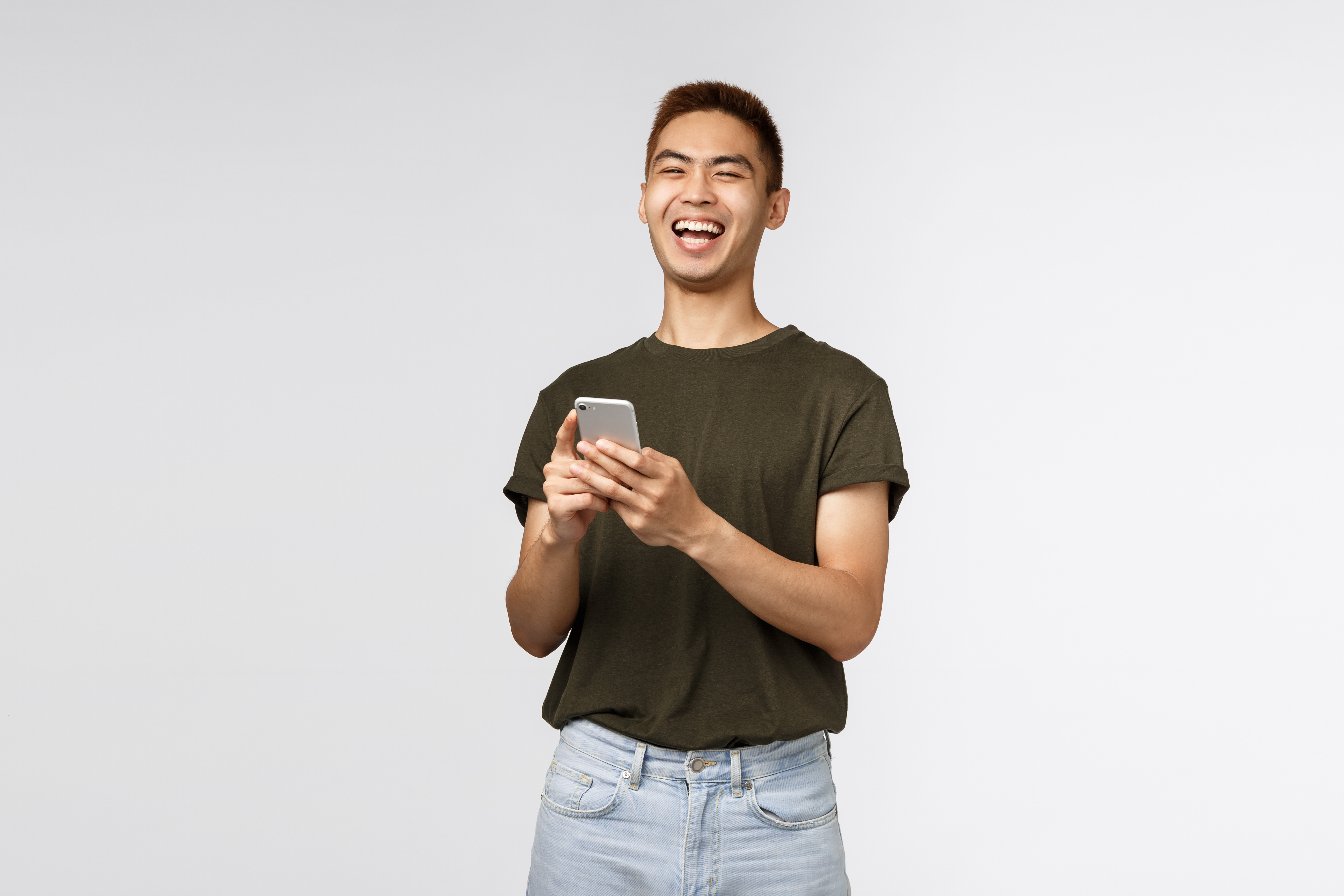 man laughing while reading something on his phone