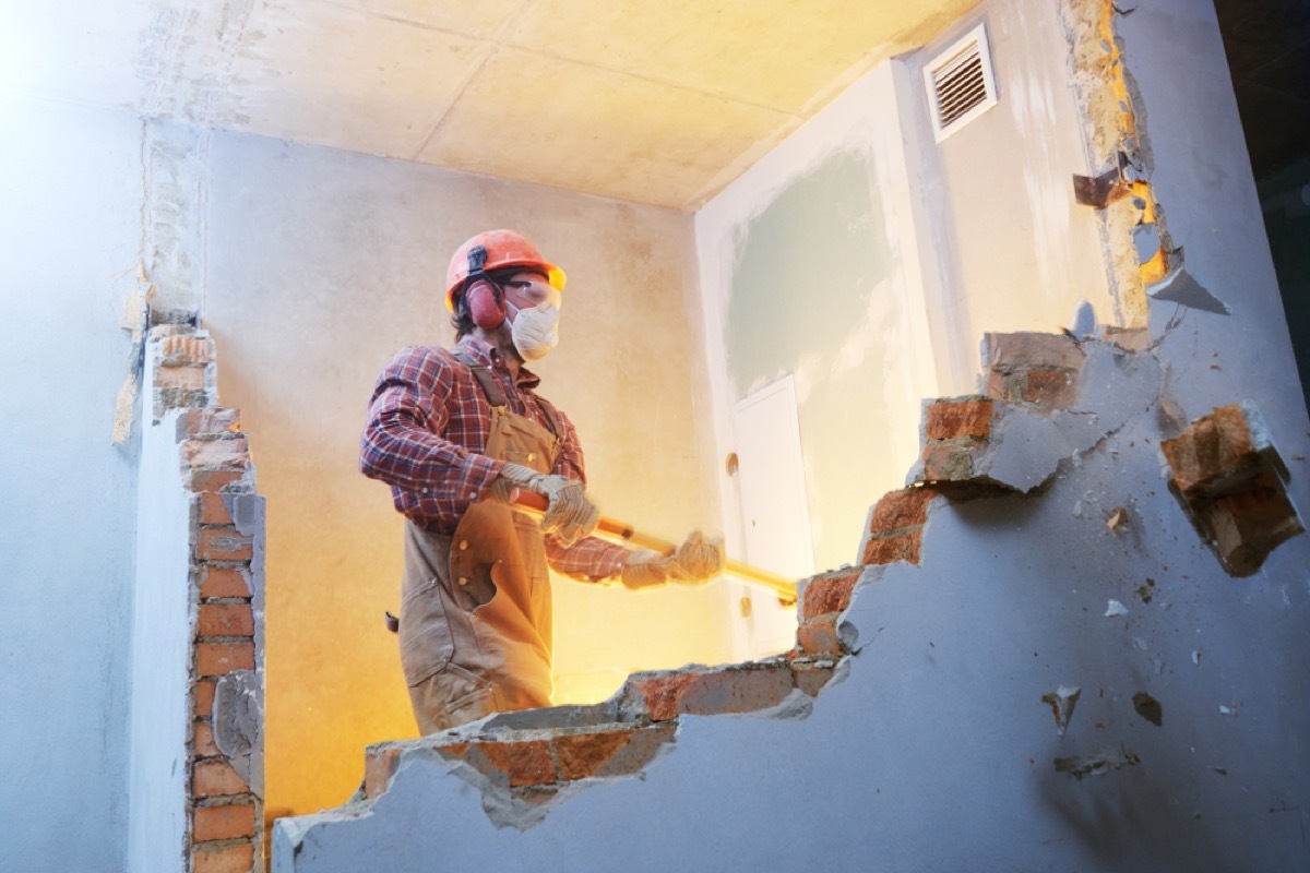 contractor knocking down brick wall