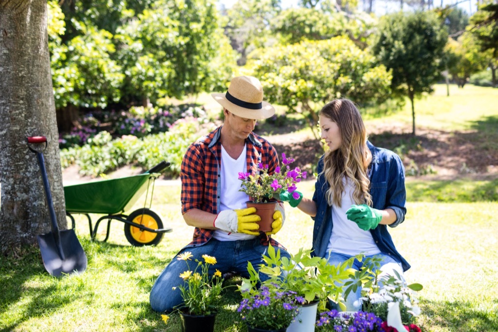 white man and woman planting flowers