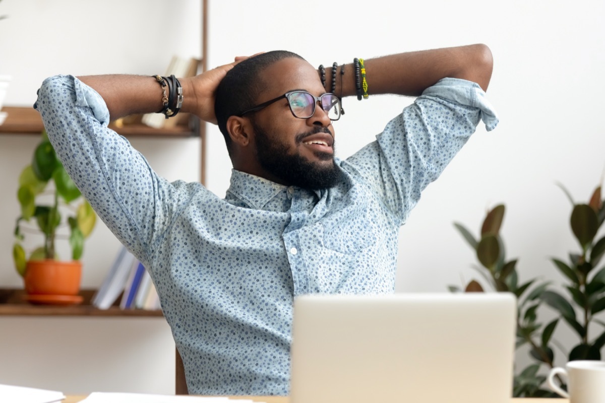 man take break at workplace relaxing finished work, happy black professional employee enjoy success rest from computer feeling stress relief peace of mind sit at desk