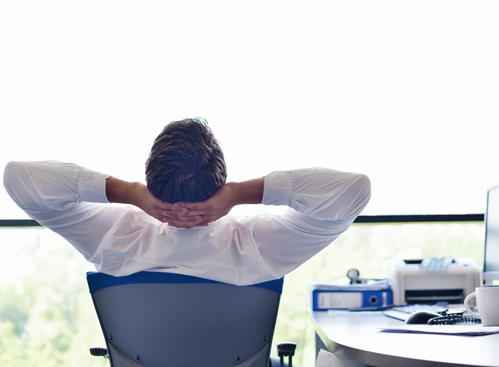 man stretching in his chair at work