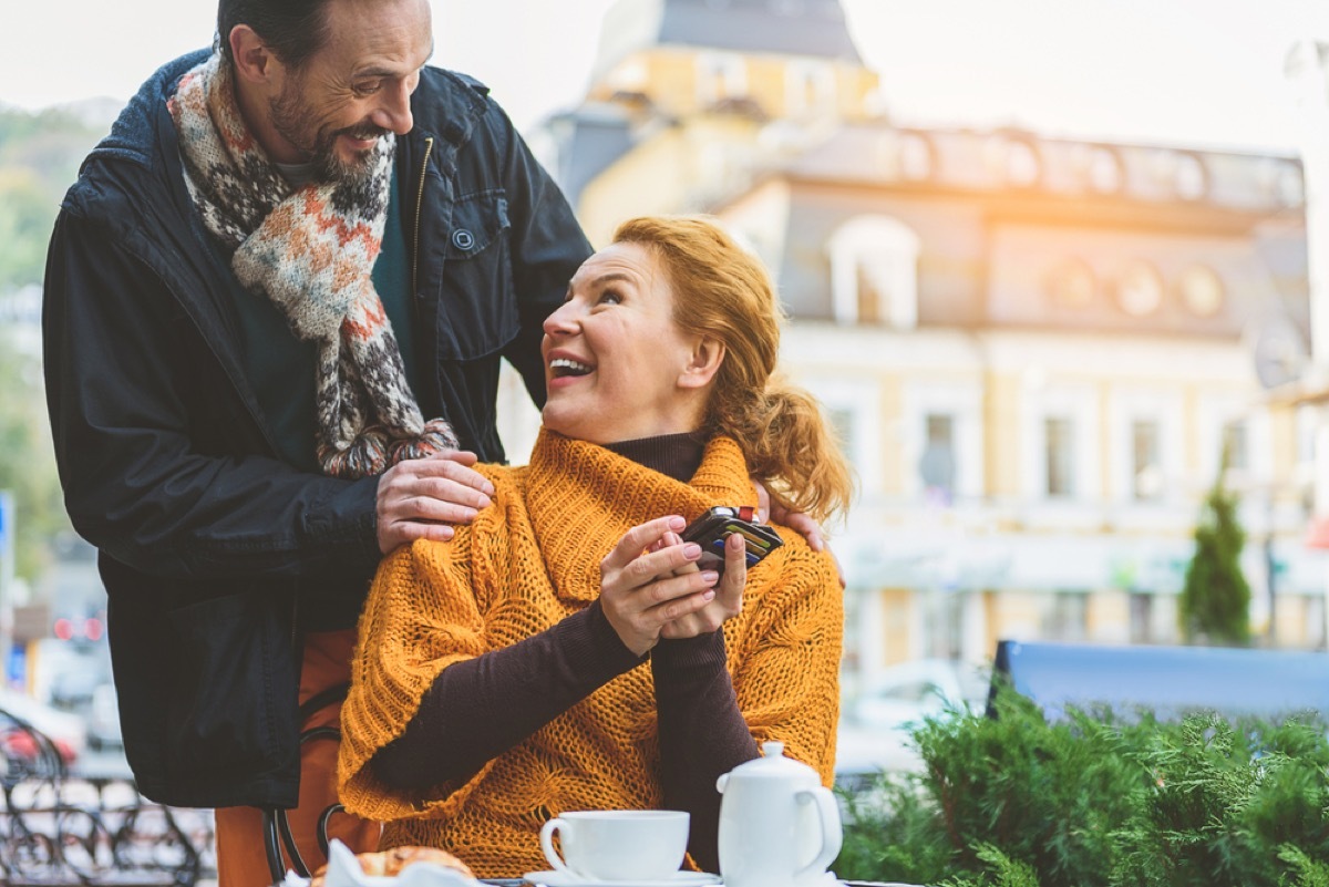 older white man greeting older white woman outside