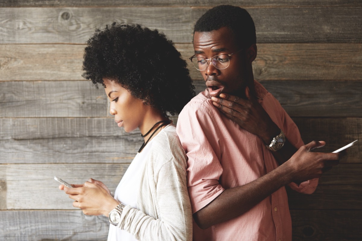 man looking at screen of girlfriend's phone