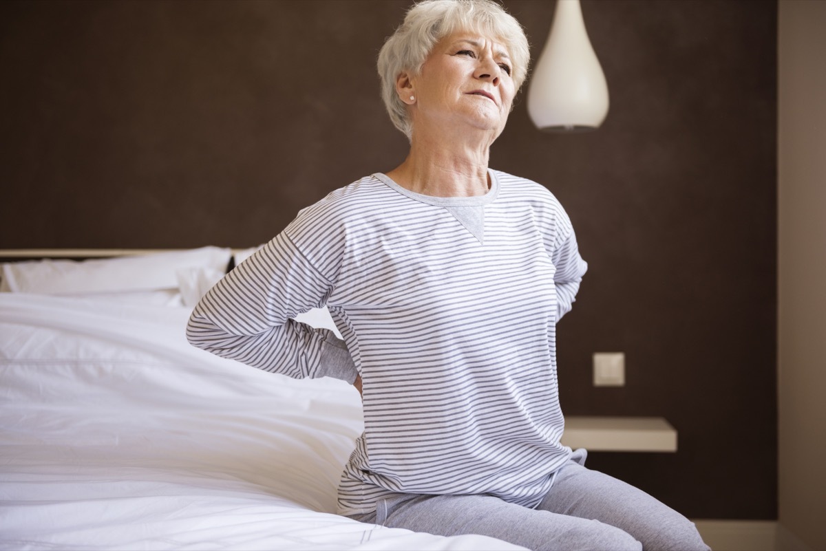 older white woman with back pain in bed