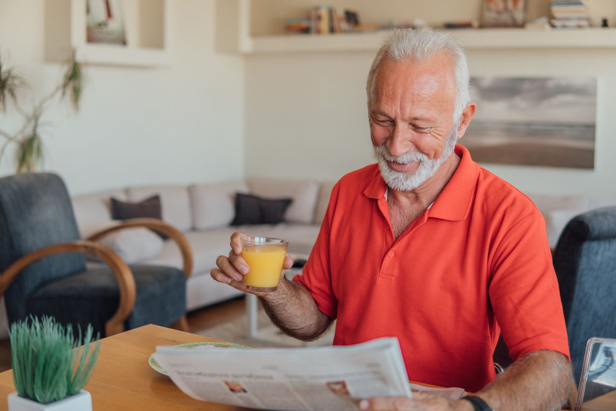 Senior man drinking orange juice.