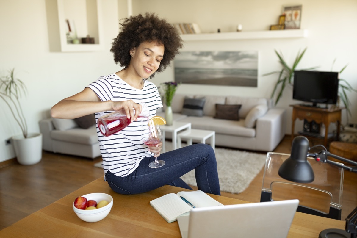 woman is relaxing, enjoying and having fun at home with some alcoholic beverage