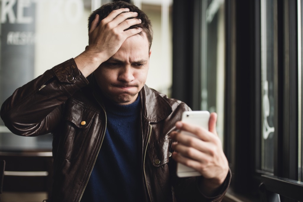 man shocked disgusted on phone