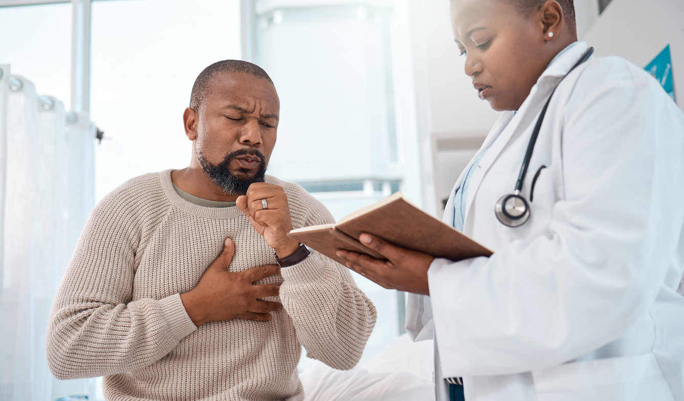 Man coughing as he speaks to a doctor. 