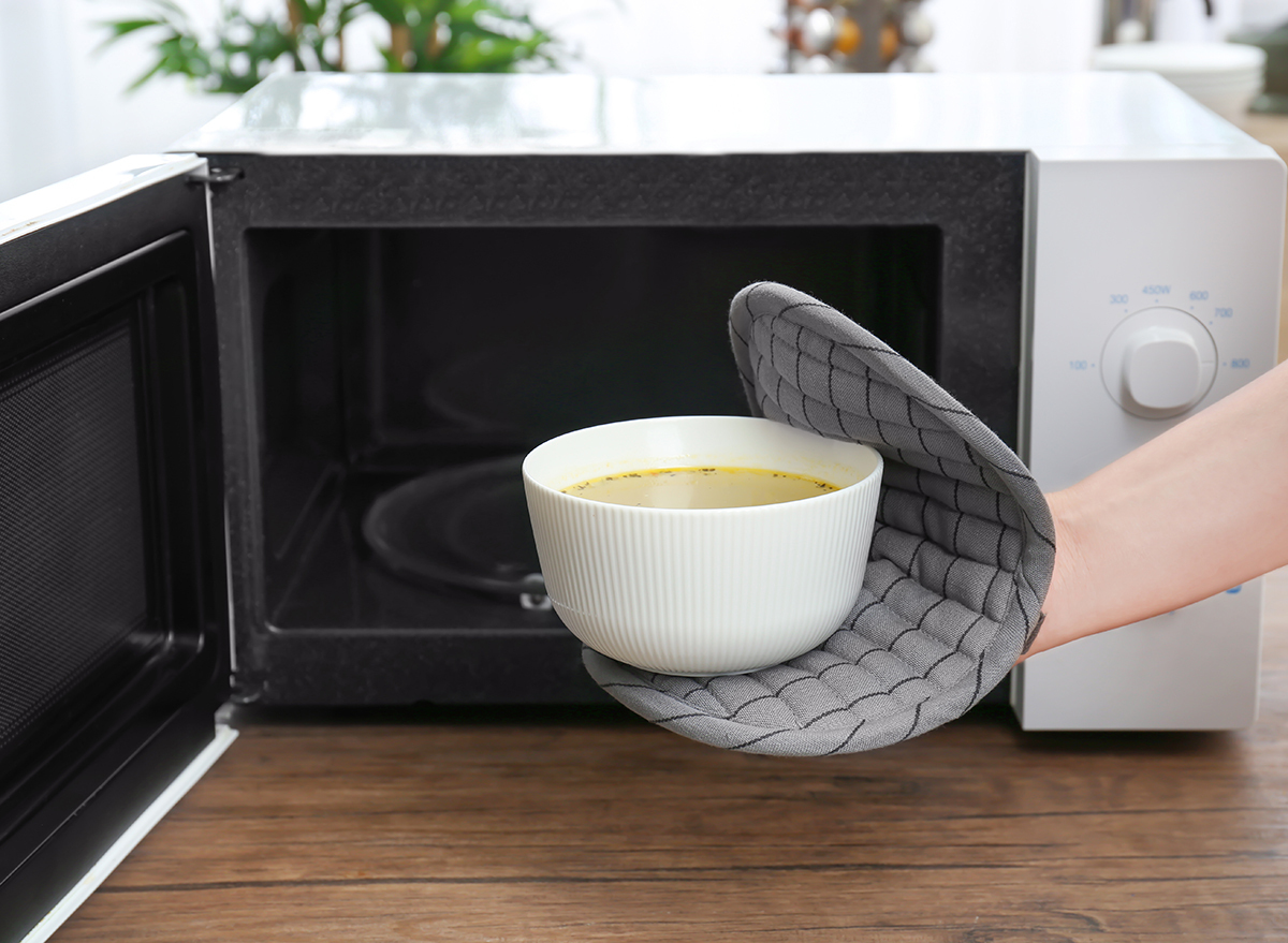 putting soup in microwave with hot pad