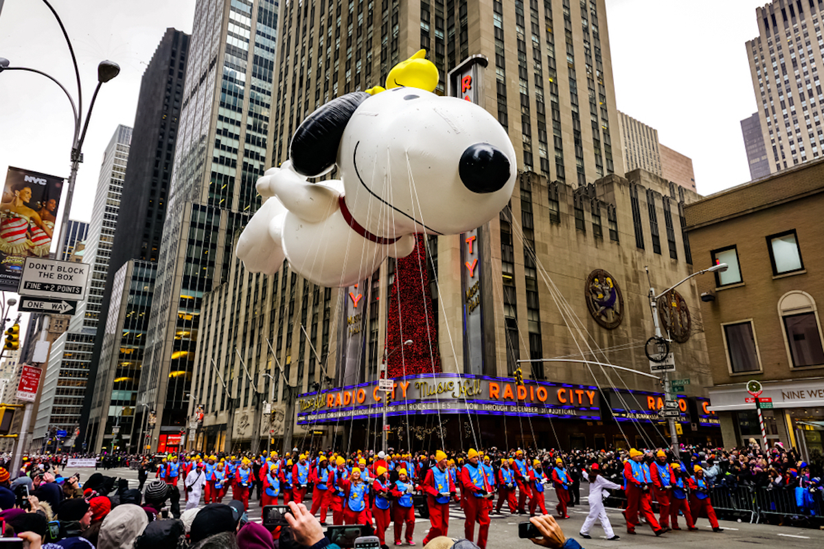 Snoopy balloon floats in the air during the annual Macy's Thanksgiving Day parade along Avenue of Americas with the Radio Music Hall in the background on November 27, 2014.