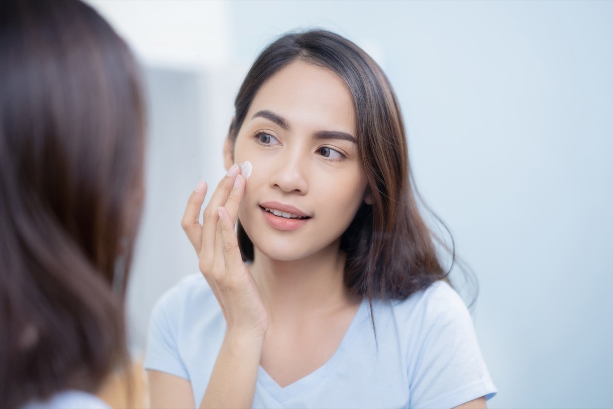 woman applying moisturizer, using objects wrong