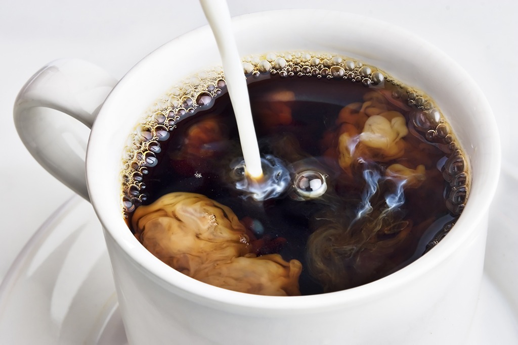 pouring cream into coffee