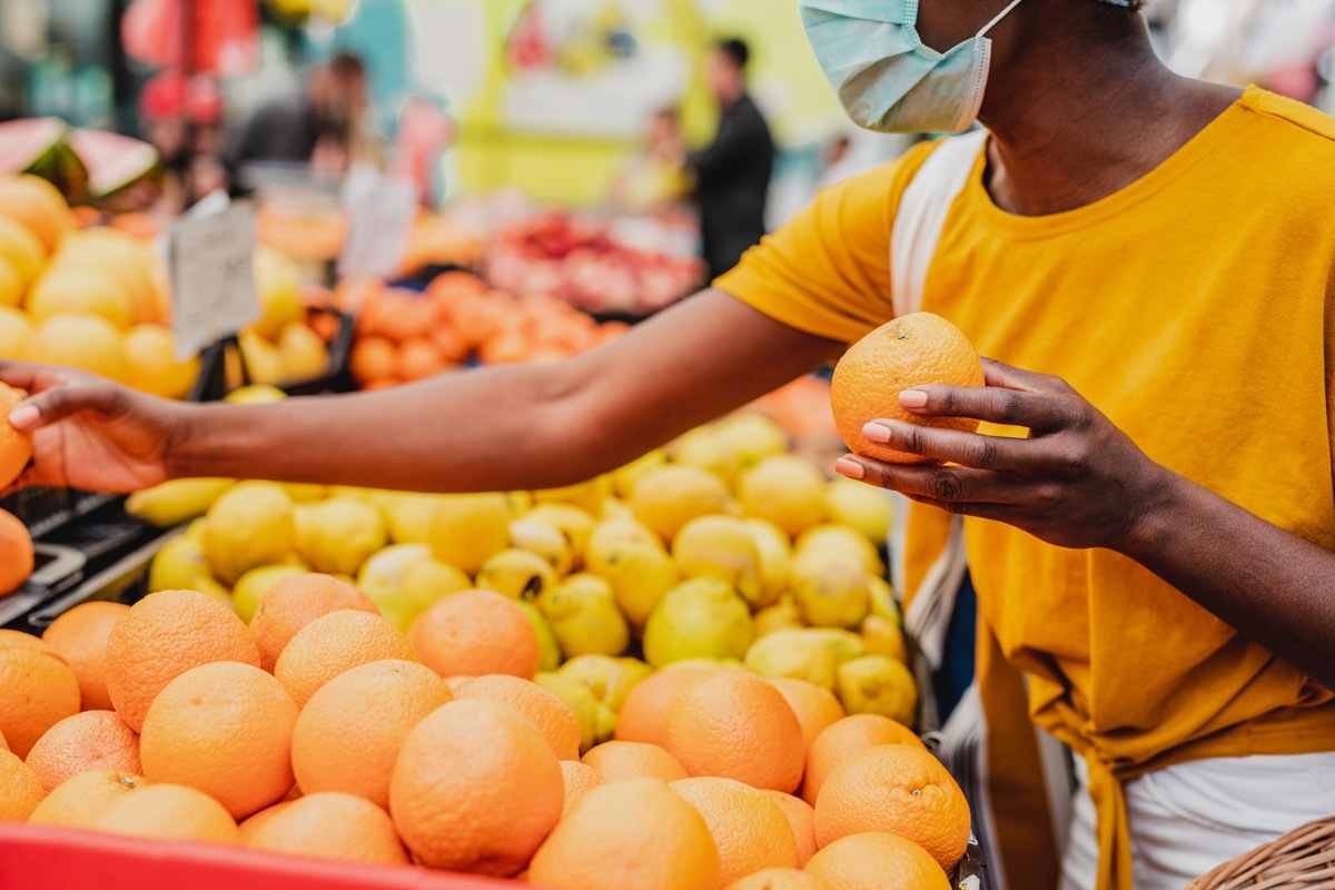 woman wearing a protective mask while buying groceries at the market