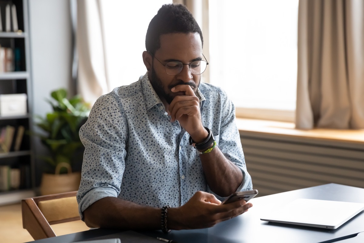 man looking concerned at smartphone