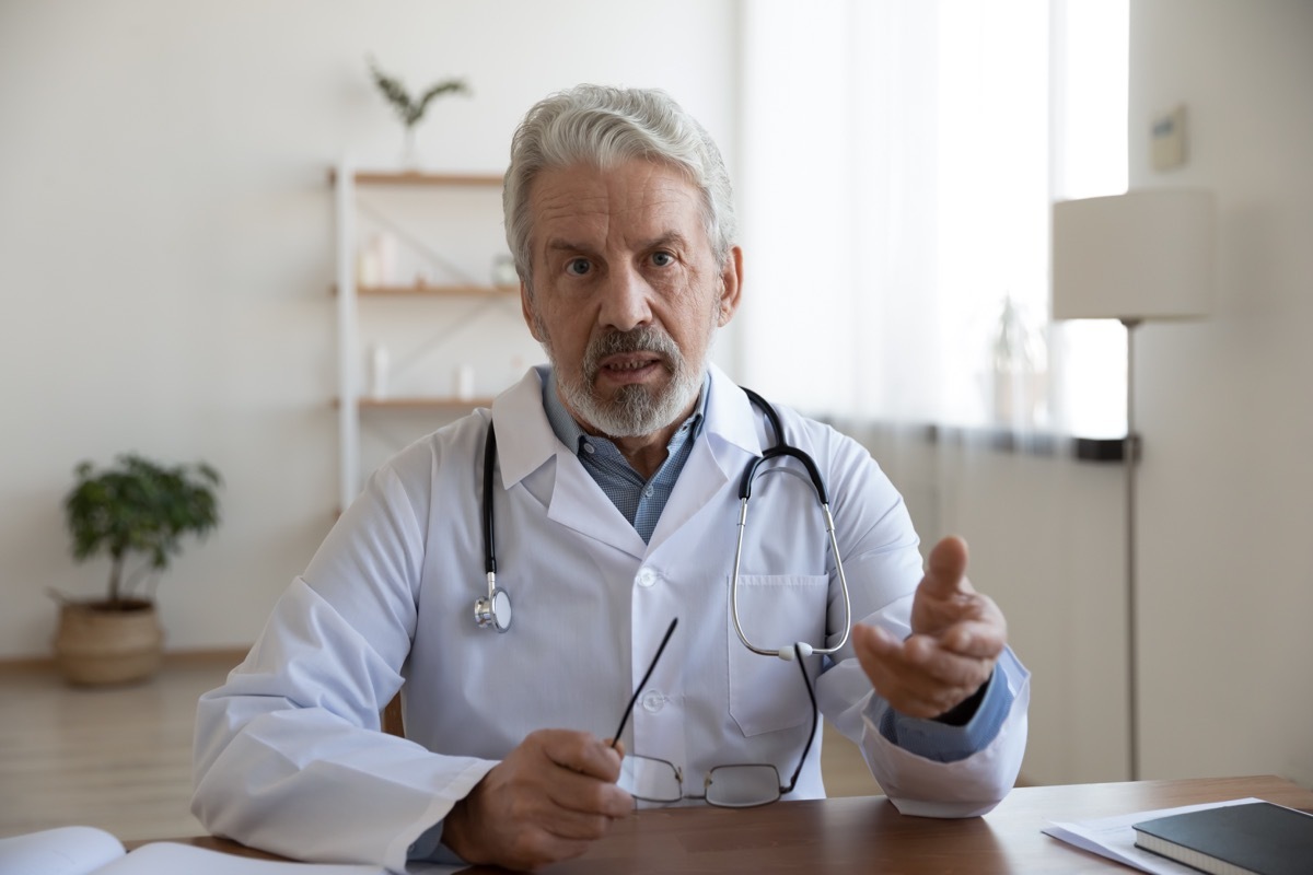 Mature doctor wearing uniform speaking at camera