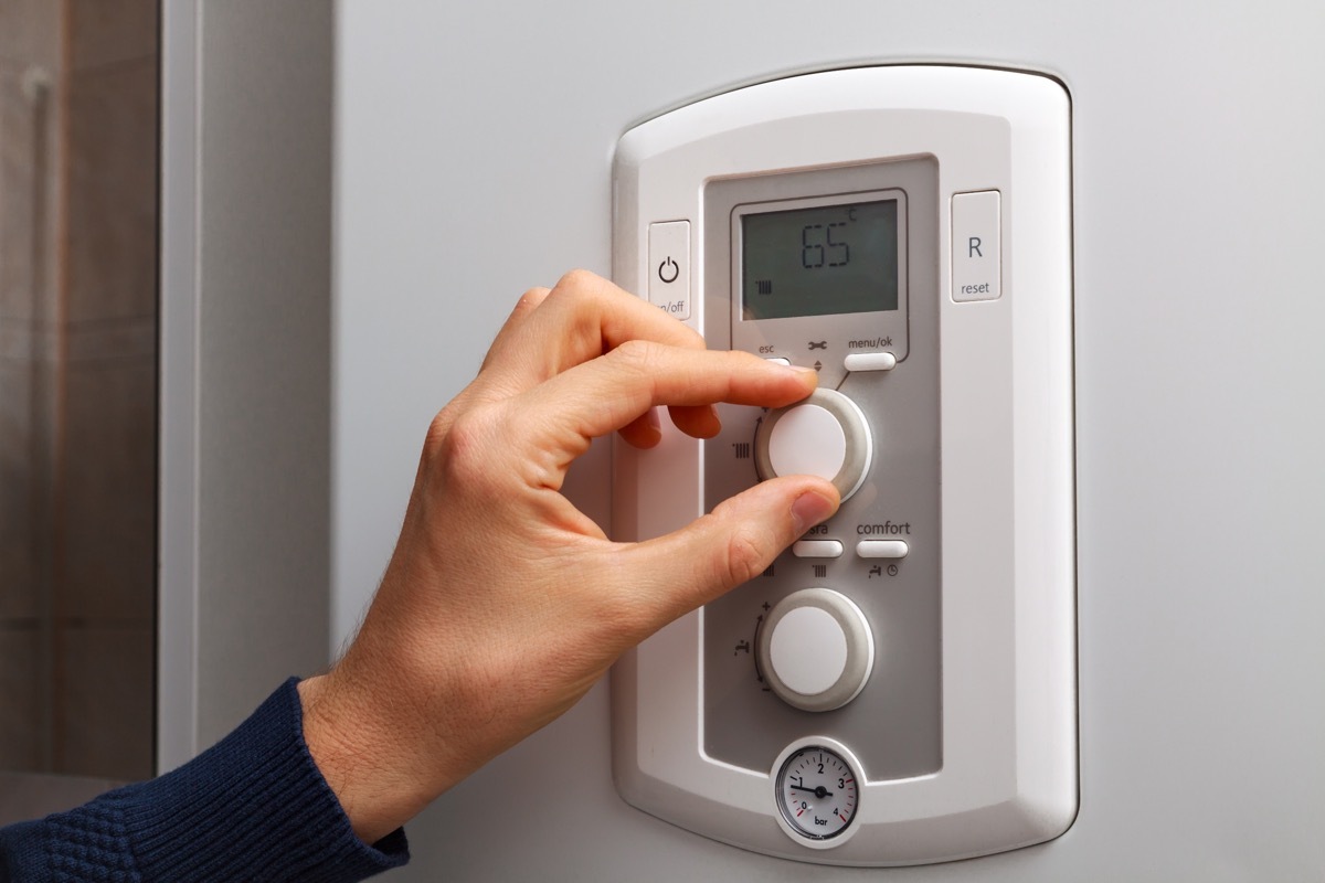 Person Adjusting Thermostat