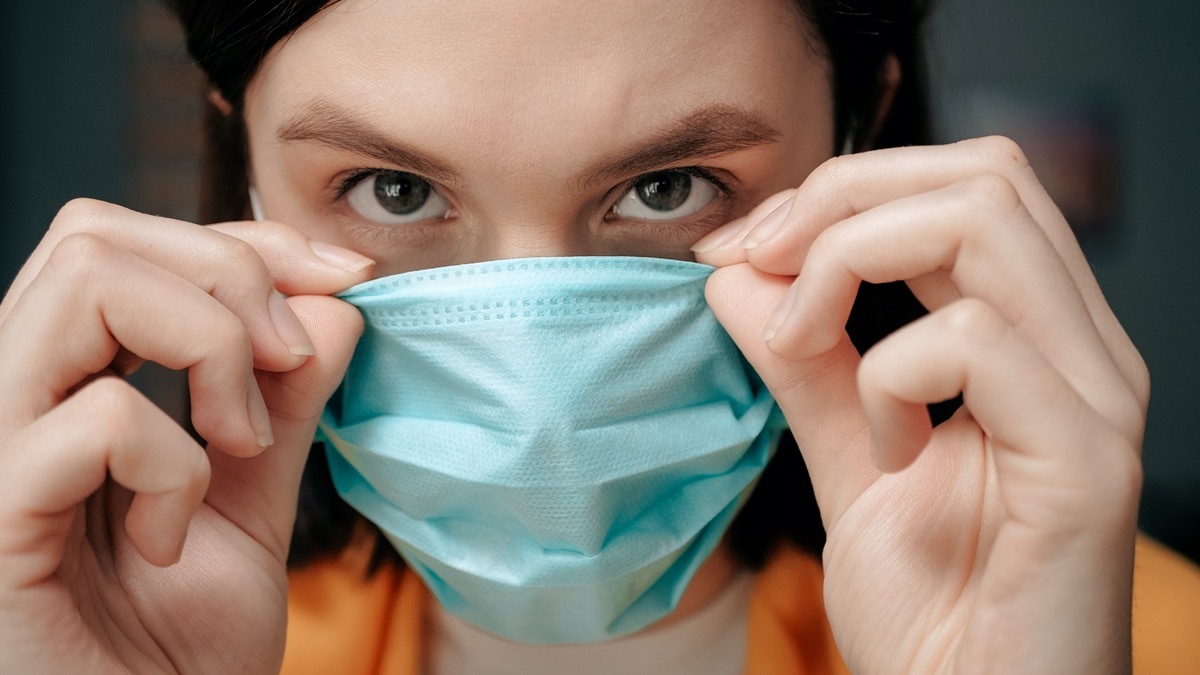 woman puts on face mask