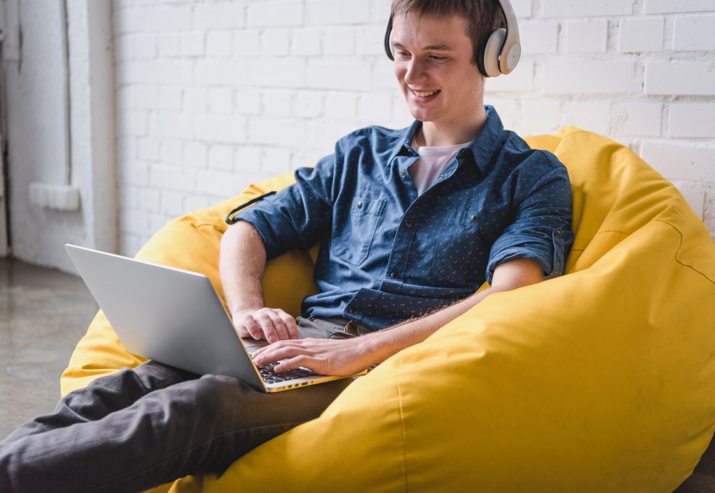 Man on Laptop and Headphones Work From Home Jobs