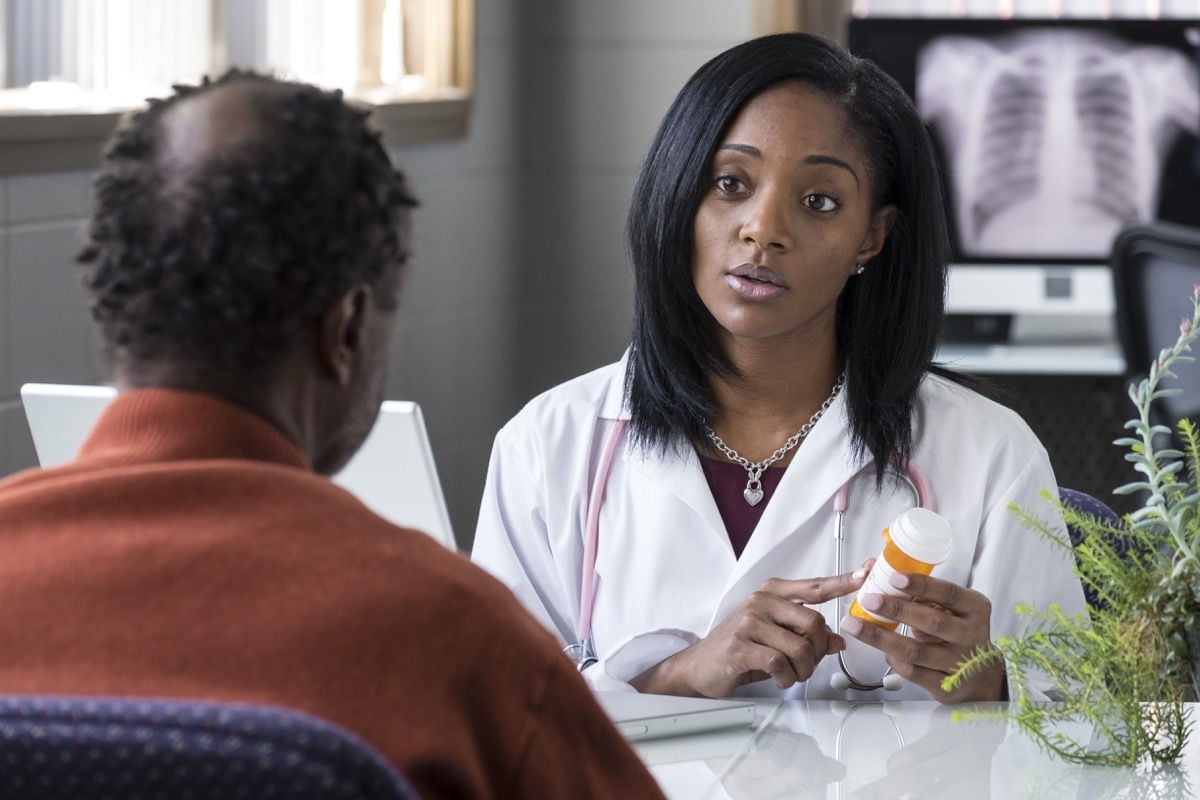 female physician prescribing pills to an older black male patient