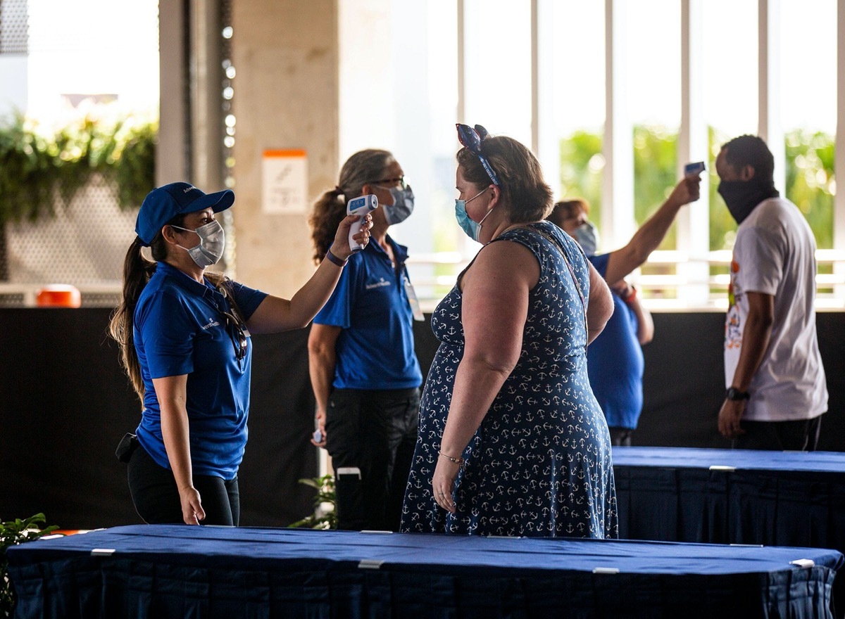 Visitors have their temperatures checked before entering Disney Springs