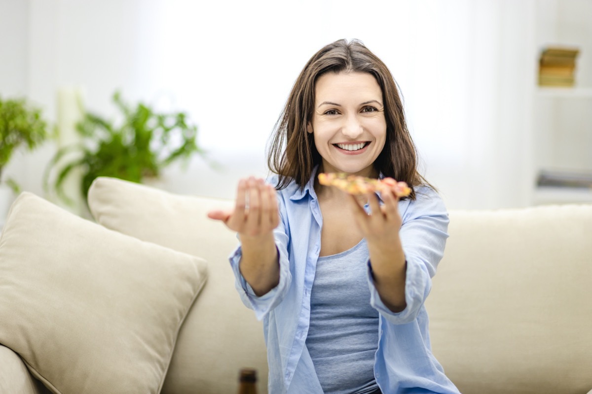 woman offers to taste delicious slice of pizza