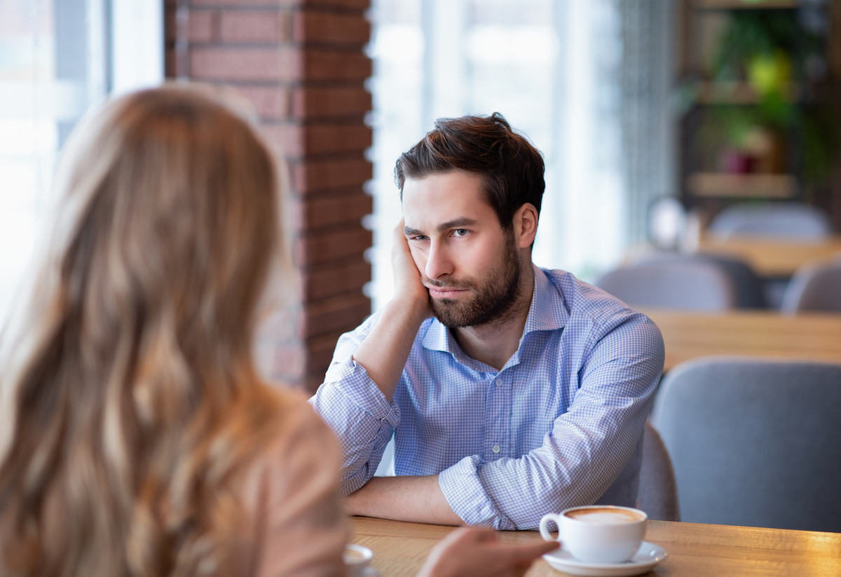 A young man looks really bored on a date with a woman