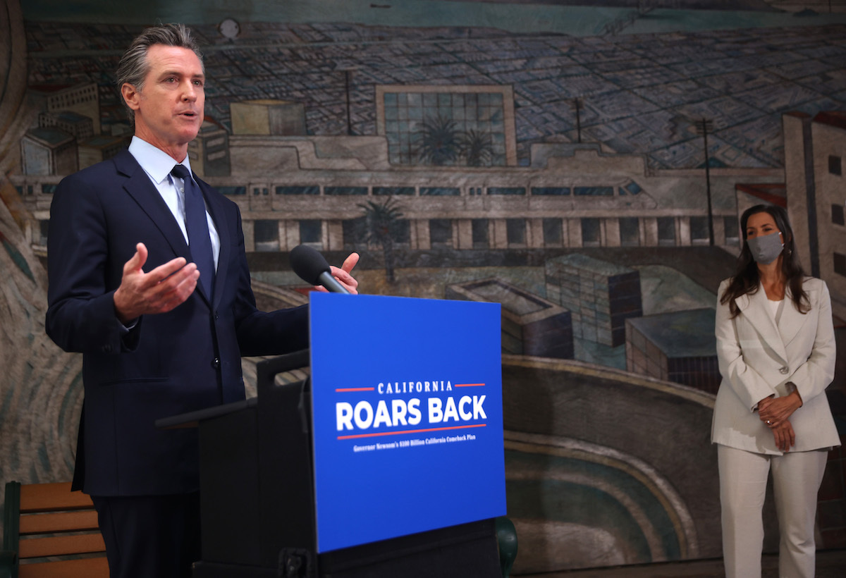 California Gov. Gavin Newsom (L) speaks during a press conference as Oakland Mayor Libby Schaff (R) looks on at The Unity Council on May 10, 2021 in Oakland, California.