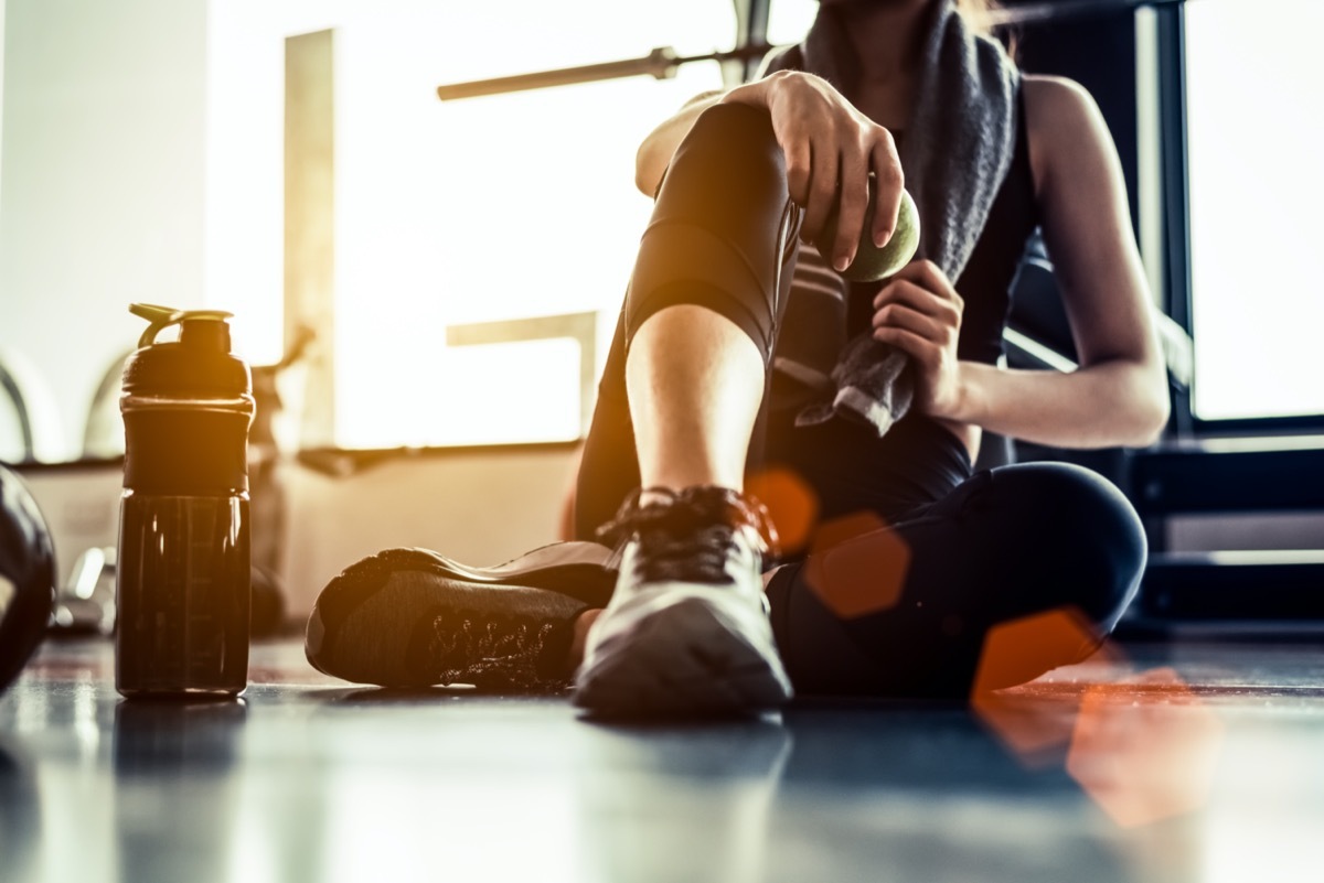 Woman sitting on gym floor after working out