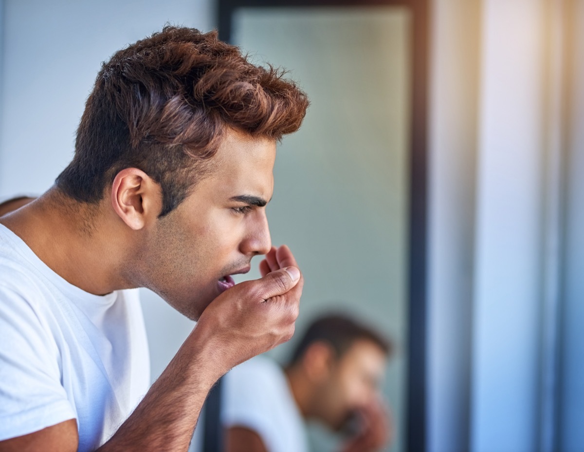 Shot of a handsome young man smelling his breath during his morning grooming routine