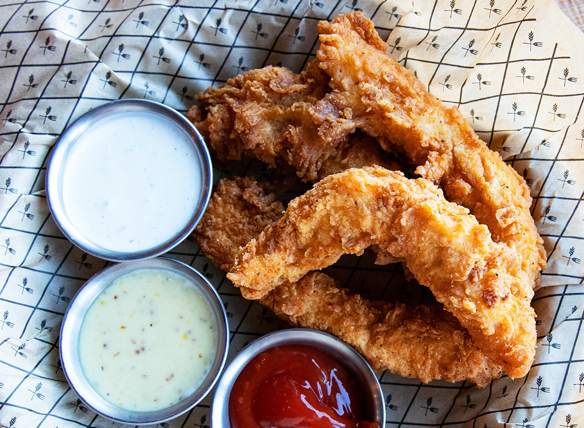 basket of chicken strips with two dips