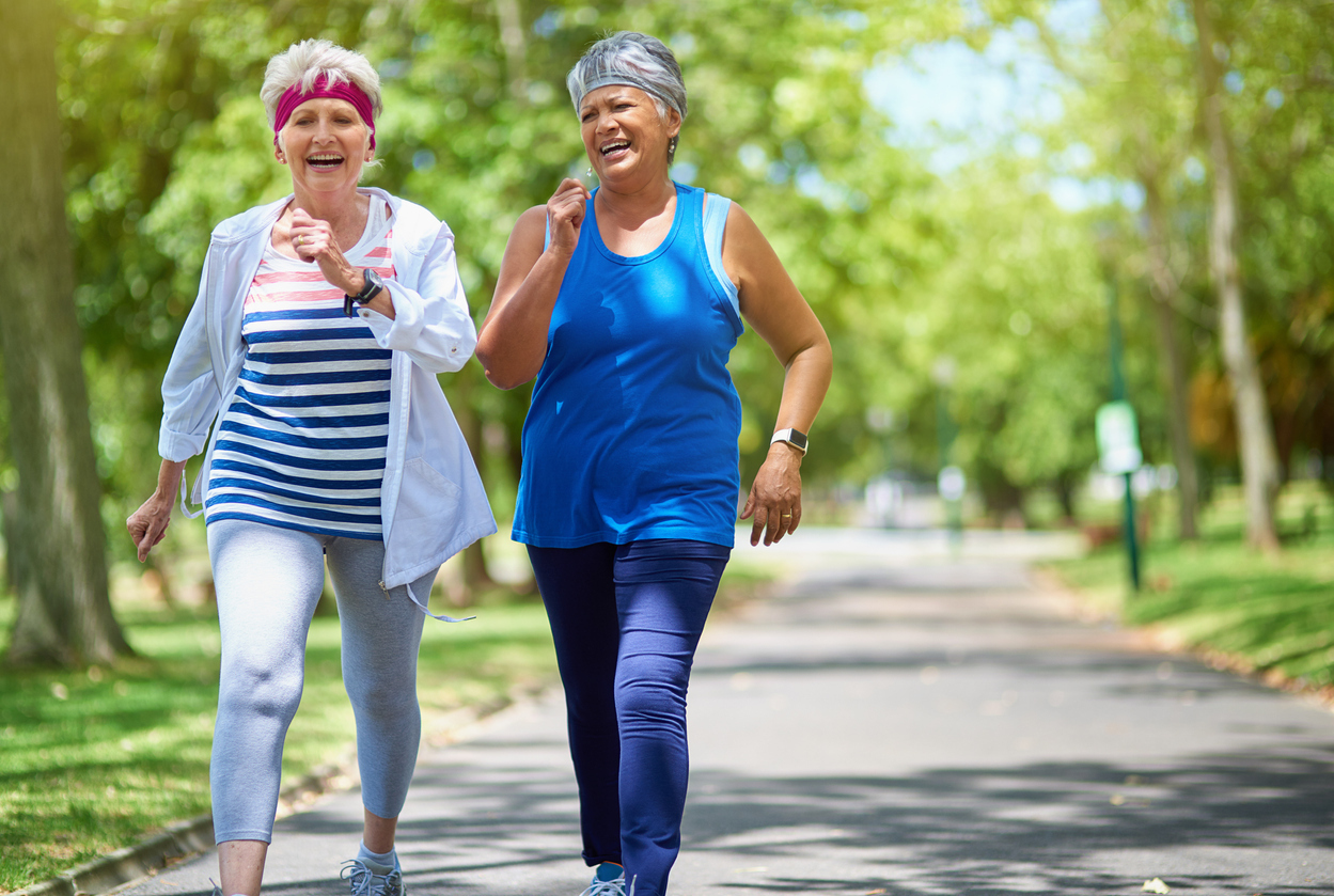 Two senior women walking outdoors.