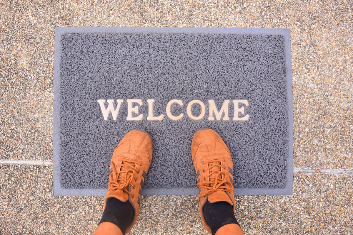 brown sneakers on a gray welcome mat