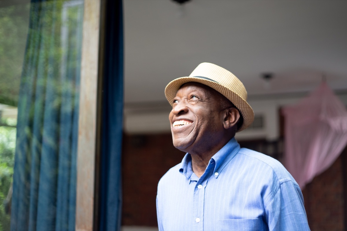 old man smiling and looking out the window