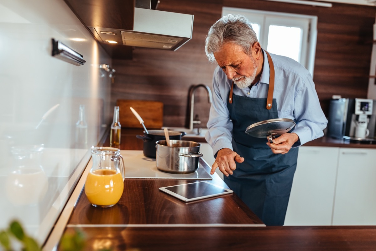 Senior man preparing delicious meal in the kitchen