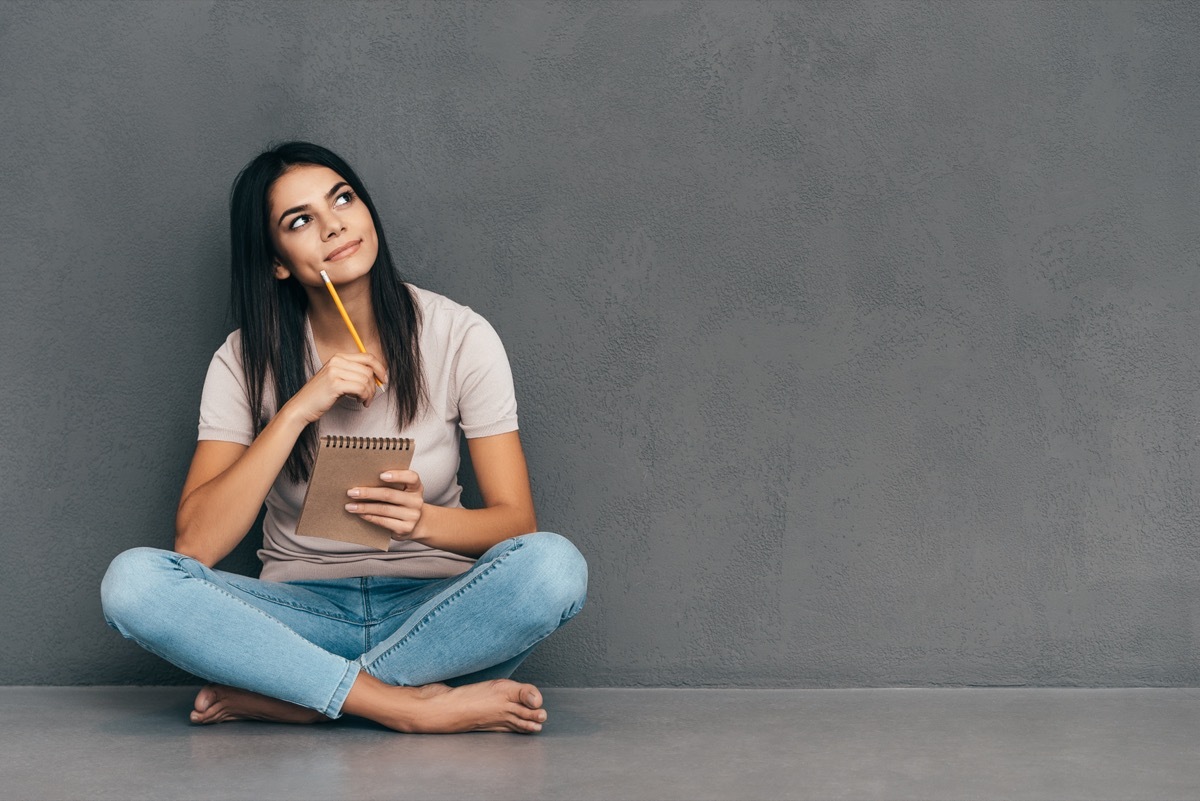 woman jotting down inspirational life quotes in notepad