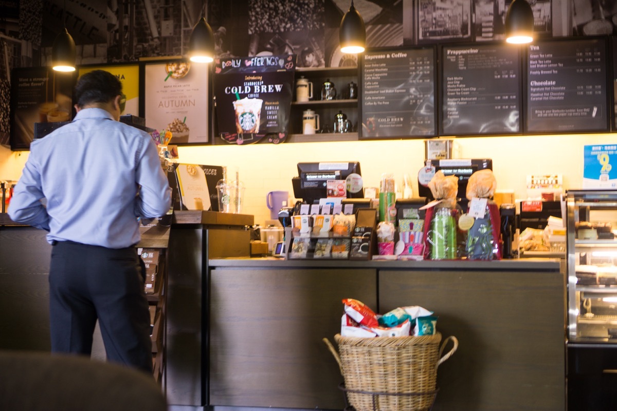 vKuala Lumpur, Malaysia - October 29 2017 : A Man stand to order beverages at Starbucks store in Putrajaya Government Office. Starbucks Corporation is an American coffee company and coffeehouse chain.