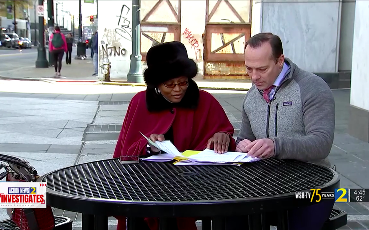 Lois White and WSB-TV Channel 2 anchor sitting at outdoor table and looking at paperwork