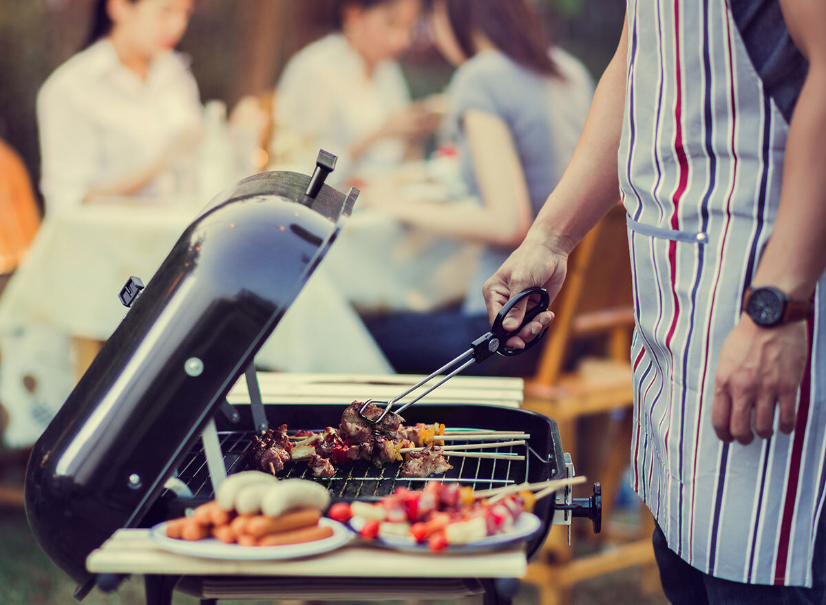 man barbecuing for family