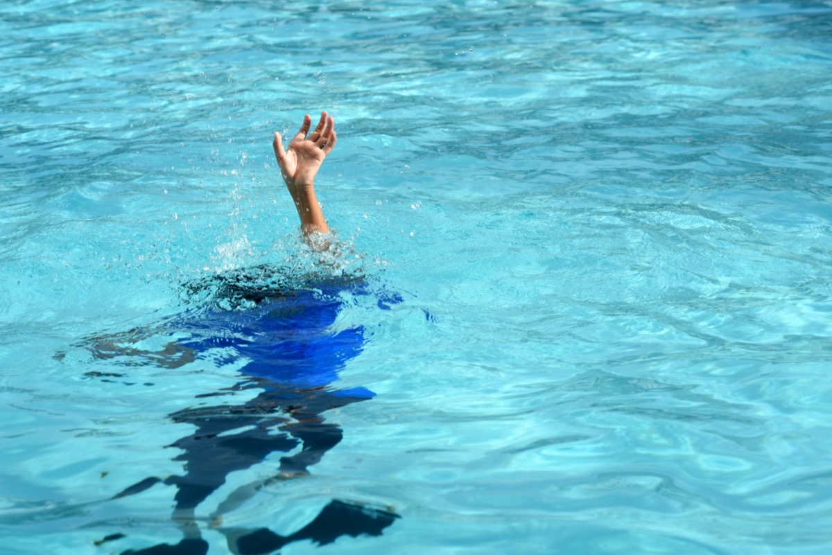 Male boy struggling underwater drowning in swimming pool. 