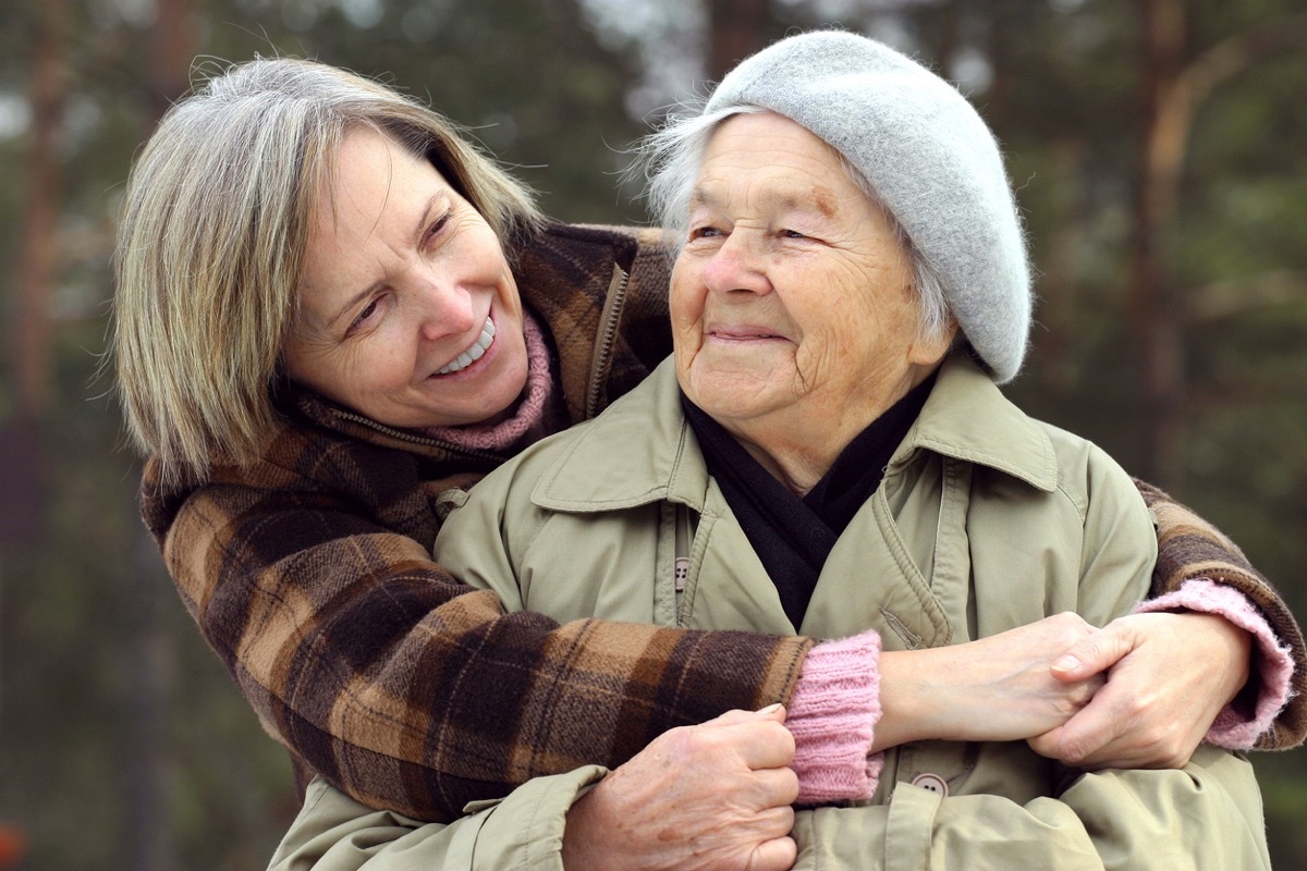 middled aged white woman hugging her mother from behind