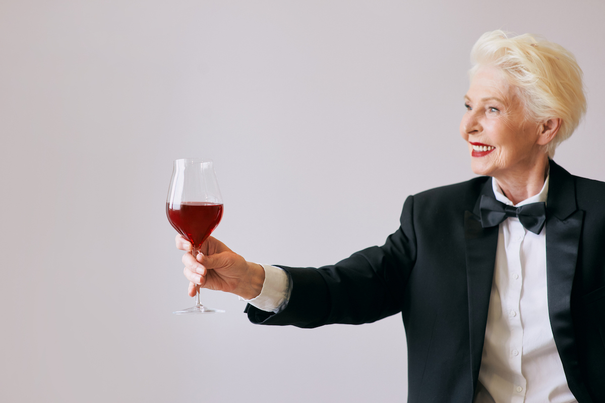 older woman with tuxedo and wine