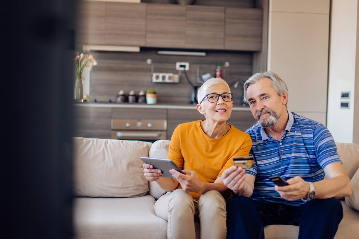 Senior couple shopping online at home.