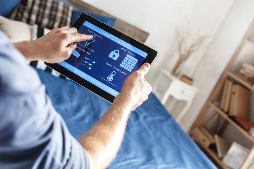 man fiddling with smart home security system on a tablet