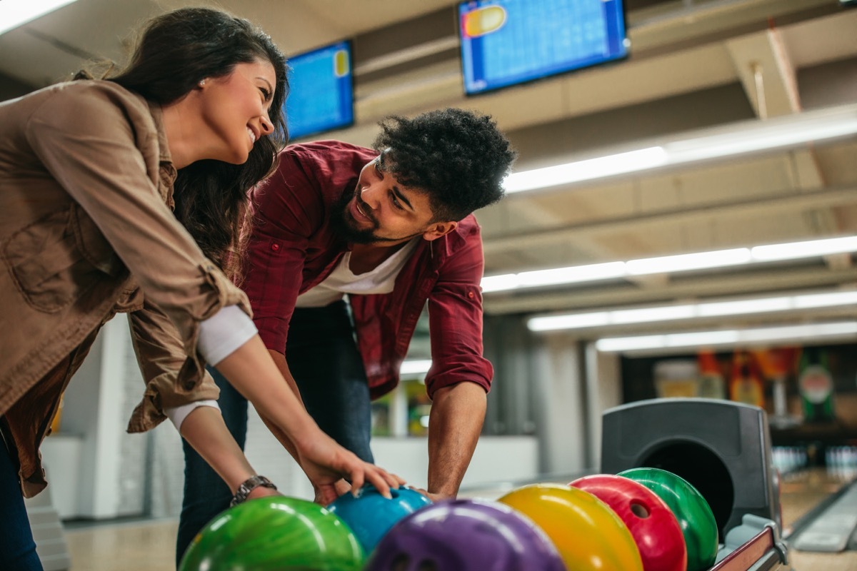 young interracial couple bowling together